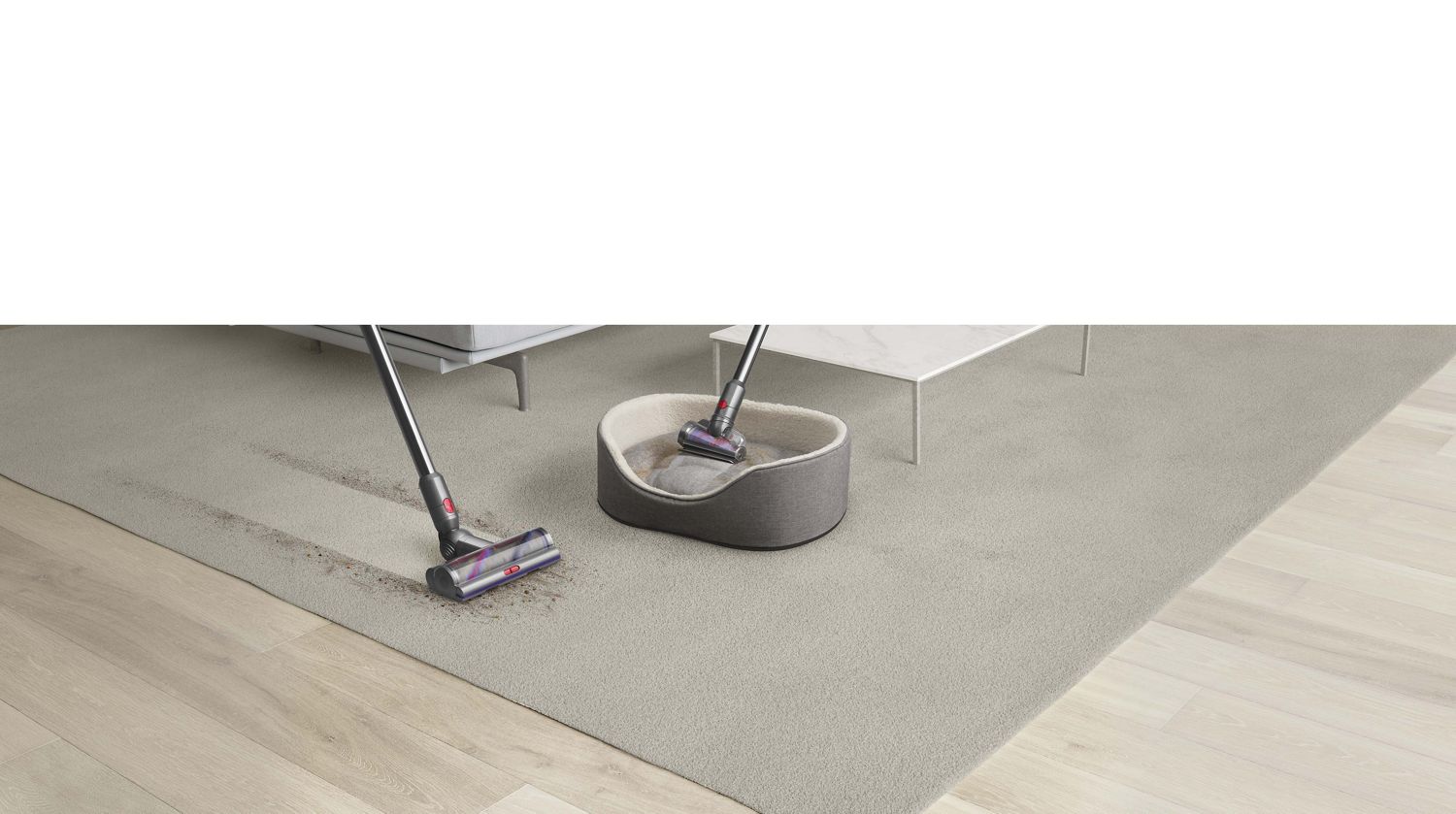Brosse auto-démêlante Dyson qui nettoie le couchage d'un animal de compagnie et tête d'aspirateur Motorbar™ qui élimine les poils d'un tapis.